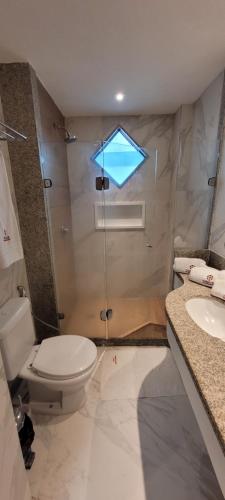 a bathroom with a toilet and a shower and a sink at Flat térreo 2 quartos no Marulhos Resort - Beira mar Muro Alto in Porto De Galinhas