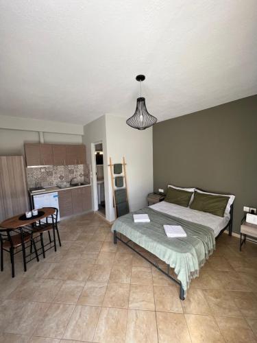 a bedroom with a bed and a table and a kitchen at kochyli studios in Asprovalta