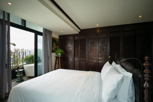 a bedroom with a large white bed with a window at Amanaki Thao Dien in Ho Chi Minh City