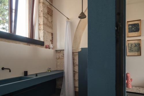a bathroom with a white shower curtain and a sink at Casa di Melo - Organic Country Hotel in Cassibile