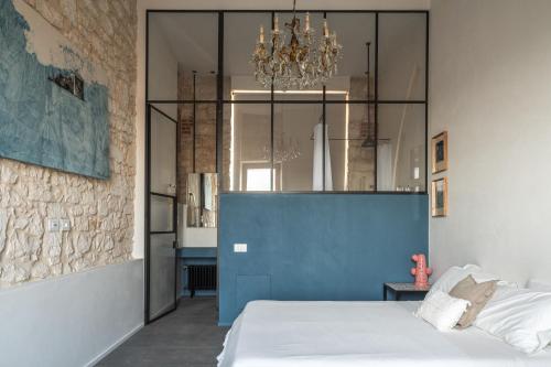 a bedroom with a blue bed and a chandelier at Casa di Melo - Organic Country Hotel in Cassibile