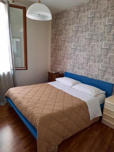 Schlafzimmer mit einem großen Bett mit blauem Kopfteil in der Unterkunft b&b del vicolo in Cesena