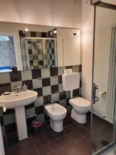 ein Badezimmer mit einem Waschbecken, einem WC und einem Spiegel in der Unterkunft b&b del vicolo in Cesena