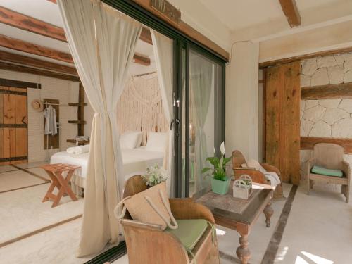a living room with a bedroom with a bed and a table at La Casa de Mia Tulum in Tulum