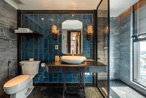 a bathroom with a sink and a toilet and a mirror at Amanaki Thao Dien in Ho Chi Minh City