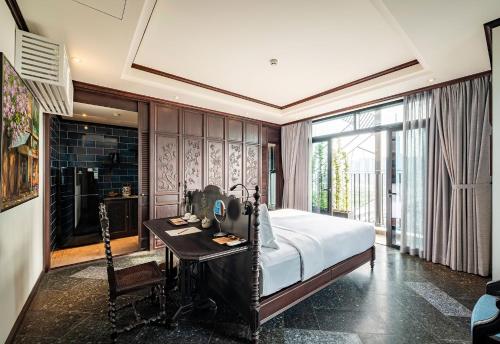 a bedroom with a bed and a desk and a window at Amanaki Thao Dien in Ho Chi Minh City