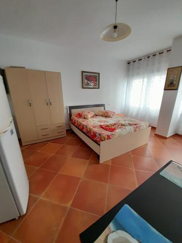 ein Schlafzimmer mit einem Bett und Fliesenboden in der Unterkunft Tomas Apartments Durres 1 in Durrës