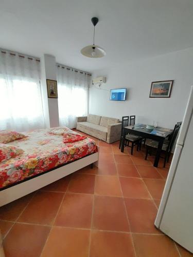 ein Schlafzimmer mit einem Bett, einem Sofa und einem Tisch in der Unterkunft Tomas Apartments Durres 1 in Durrës