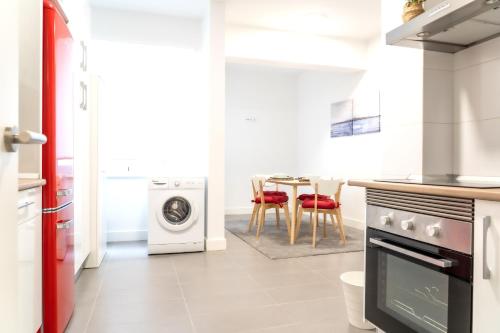 a kitchen with a washing machine and a table at DADO HOST in Vigo