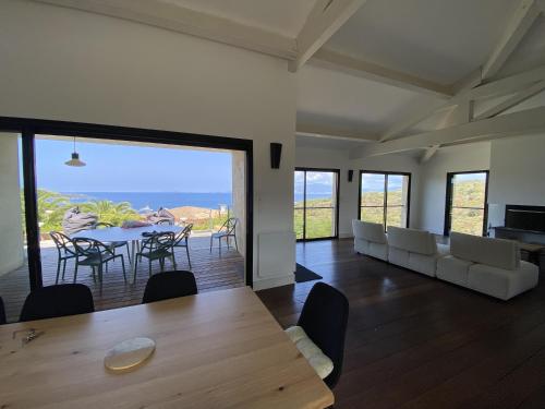 ein Wohnzimmer mit einem Tisch und Stühlen sowie Meerblick in der Unterkunft Magnifique villa vue mer avec piscine in Coti-Chiavari