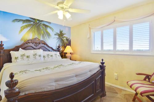 - une chambre avec un grand lit et un ventilateur de plafond dans l'établissement Sunset Chateau 506 - Premier, à St. Pete Beach