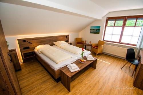 - une chambre avec un grand lit et une table dans l'établissement Hotel Zwei Linden - links der Elbe - Niedersachsen, à Balje