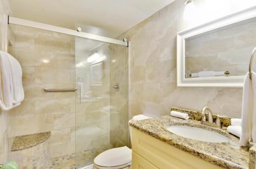 La salle de bains est pourvue d'une douche, d'un lavabo et de toilettes. dans l'établissement Sunset Chateau 506 - Premier, à St. Pete Beach