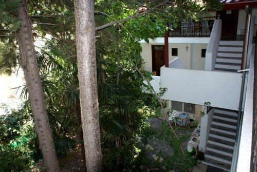 una vista al aire libre de una casa con árboles y escaleras en HOTEL AGNI -ENOIKIAZOMENA DIAMERIZMATA, en Kallithea Halkidikis