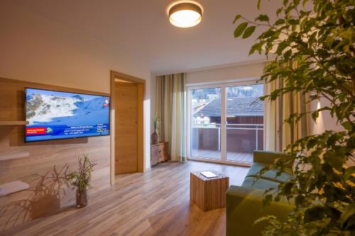 sala de estar con TV de pantalla plana grande en Aparthotel AlpTirol en Kaltenbach