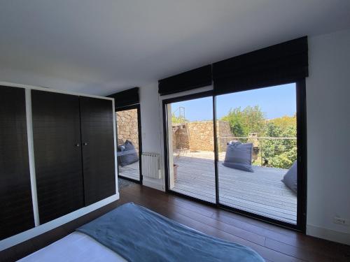 Schlafzimmer mit einem großen Fenster mit Blick auf eine Terrasse in der Unterkunft Magnifique villa vue mer avec piscine in Coti-Chiavari