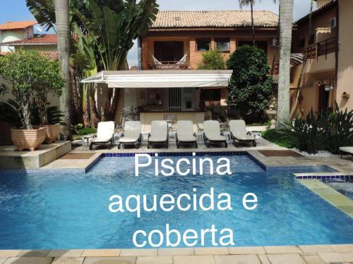 una piscina del complejo con un cartel que lee pisaacco analgesica colombo en Hotel Costa Balena-Piscina Aquecida Coberta, en Guarujá