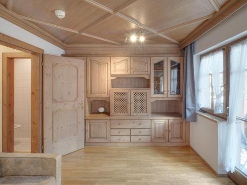 a kitchen with wooden cabinets and a ceiling at Center Rooms & Apartments in Mayrhofen