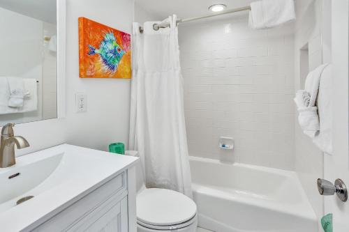 Baño blanco con aseo y lavamanos en Sunset Villas 2, en Clearwater Beach