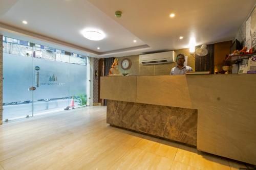 a man standing behind a counter in a kitchen at Hotel Tripple Tree - Karol Bagh in New Delhi