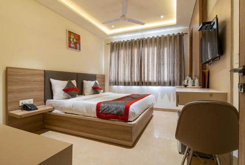 a bedroom with a bed and a desk and a television at Hotel Tripple Tree - Karol Bagh in New Delhi