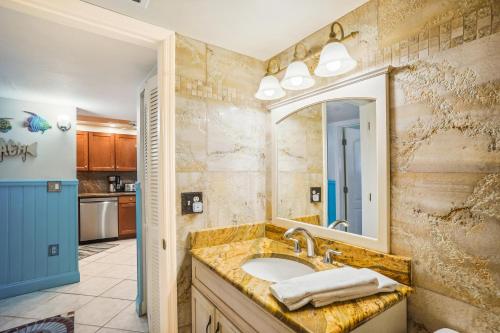 un baño con lavabo y espejo en Villa Madeira 504 - Premier, en St Pete Beach