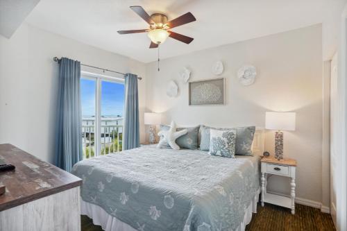 1 dormitorio con 1 cama y ventilador de techo en Sunset Vistas 407S en St Pete Beach