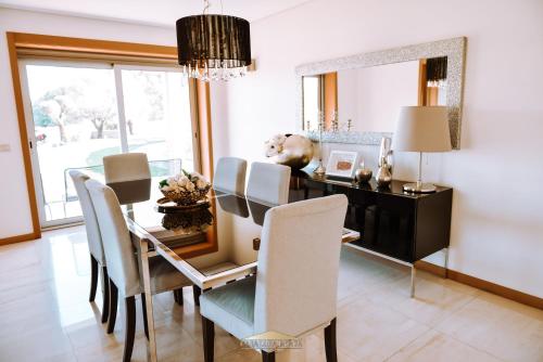 a dining room with a table and chairs and a mirror at Casa Lima Braga in Braga