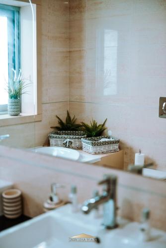 a bathroom with two sinks and a mirror and plants at Casa Lima Braga in Braga