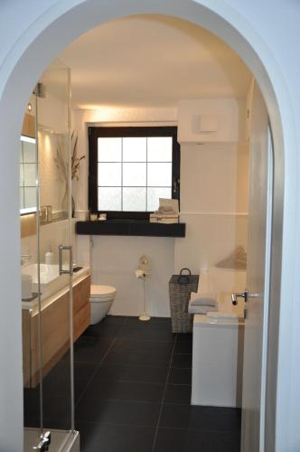 een badkamer met een wastafel, een toilet en een raam bij Ferienwohnung Rureifel in Nideggen