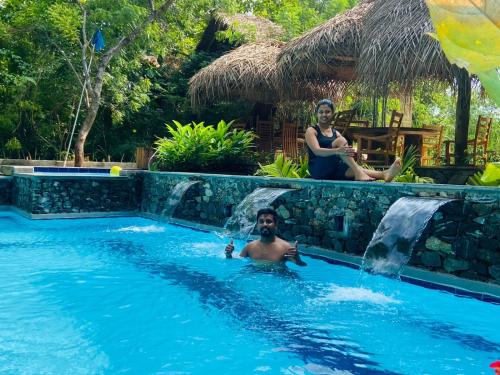 mężczyzna i kobieta w basenie w obiekcie Habarana Tree House Ambasewana Resort w mieście Habarana
