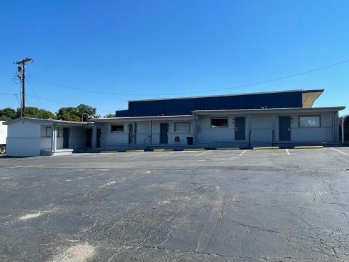 an empty parking lot in front of a building at Budget Inn Madill in Madill