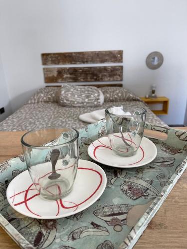twee lege glazen en borden op een houten tafel bij 3H MALARGÜE Monoambiente in Malargüe