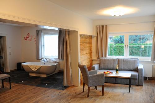 a living room with a tub and a couch and a bath tub at Hotelanlage Starick in Lübbenau