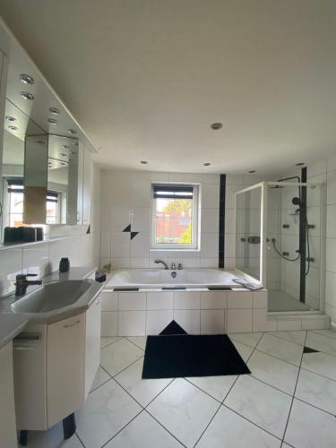 a bathroom with a tub and a sink and a shower at Ferienwohnung Limes am Kocher in Hüttlingen