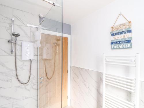a shower with a glass door in a bathroom at Chy An Mor in Mevagissey