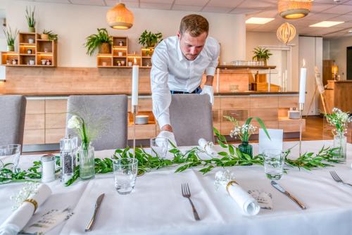a chef preparing a table in a restaurant at Hotel Beckmann in Göttingen
