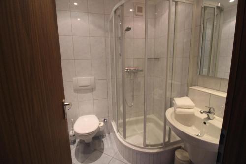 y baño con ducha, aseo y lavamanos. en Haus Norderhoog Wohnung 64, en Westerland
