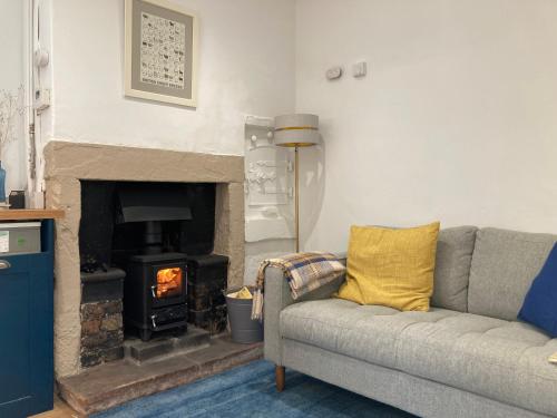 a living room with a couch and a fireplace at Penny End, Mosser - Western Lakes and great walks in Cockermouth