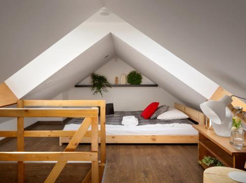 a bedroom with a bed in a attic at Apartamenty U Harrego I Przy Stawie Spa in Kudowa-Zdrój