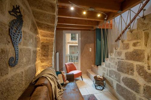 a room with a stone wall with a cat on the wall at L'Hippocampe in Bouzigues