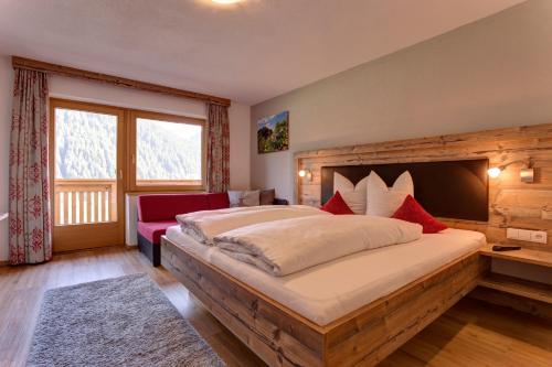 1 dormitorio con cama grande y ventana grande en Pension Roman, en Pettneu am Arlberg