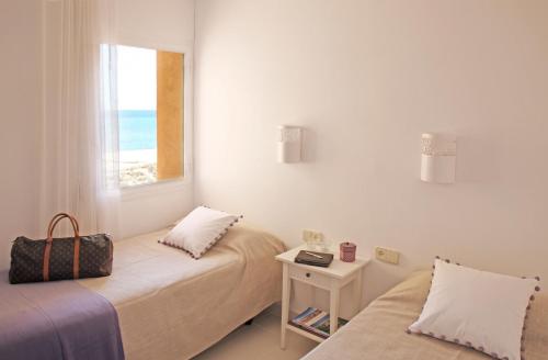 een slaapkamer met 2 bedden en een raam met uitzicht op het strand bij Apartamentos Golf Mar by La Costa Resort in Pals