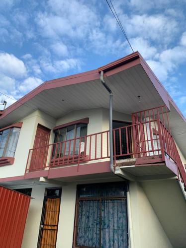 una casa con balcones rojos encima en Volcano view house, en Fortuna