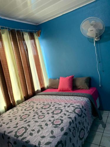 1 dormitorio con 1 cama con almohada rosa y ventilador en Volcano view house, en Fortuna