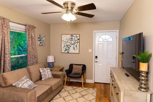 a living room with a couch and a ceiling fan at The robin nest a cozy cottage on historic main street in St. Charles