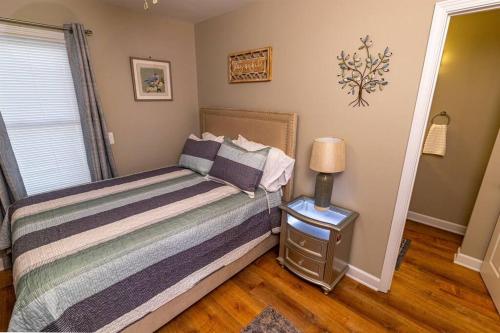 a bedroom with a bed and a lamp on a night stand at The robin nest a cozy cottage on historic main street in St. Charles