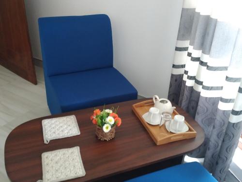 a room with a table and a blue chair and a table and a blue chair at Holly House Homestay in Ella