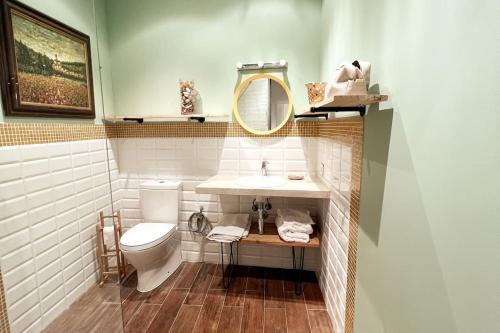 une salle de bain avec toilettes, lavabo et miroir dans l'établissement Casa de los Recuerdos, à Cuéllar