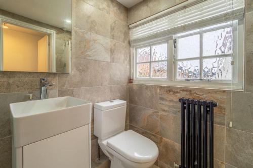baño con aseo y lavabo y ventana en Crown Street, en Bury Saint Edmunds